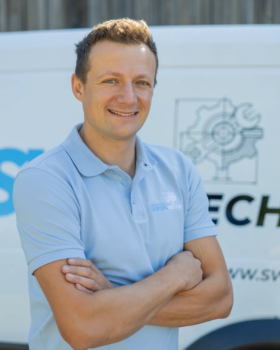 Andreas Schmid-Waldenberger vor dem Firmenauto von SWA Technik